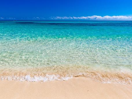 Sandstrand mit Meer und blauem wolkenlosem Himmel